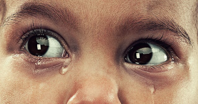 A child overcome with emotions, shedding tears.
