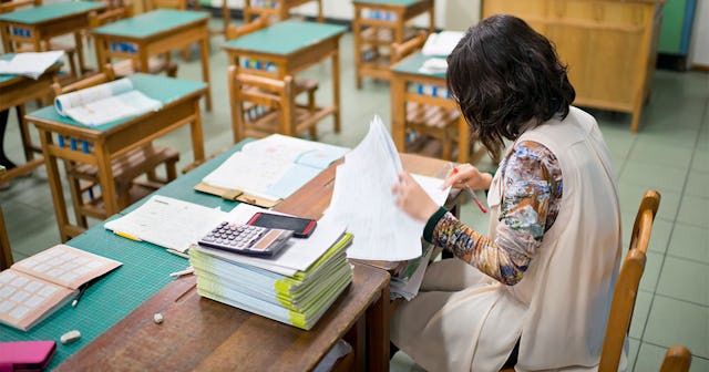 A 4th grade teacher checking exams
