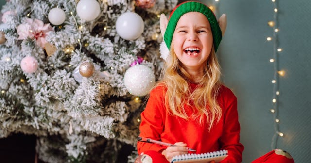 Girl in elf hat laughing — elf jokes and elf puns