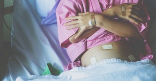 A woman with a few bandages in a hospital bed after a hysterectomy