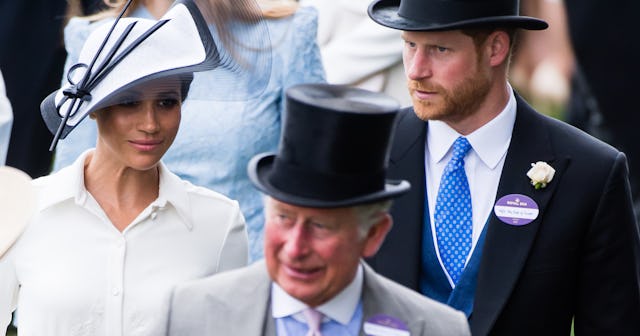 Prince Charles walking in front of Prince Harry and Meghan Markle