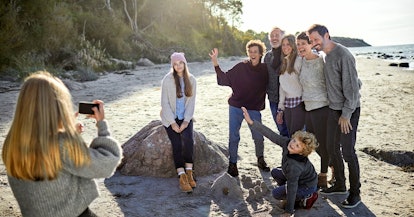 Family taking photos on the beach — large family photo ideas