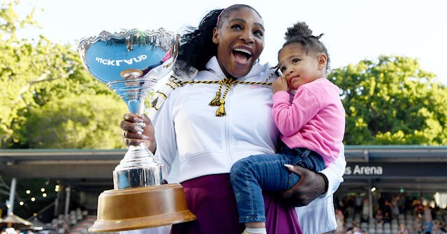 Serena Williams, who wrote her first kids book holding her daughter and a trophy while smiling 