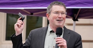 Congressman Thomas Massie giving a speech with a gun in his hand