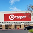 The front view of t a Target store with a red billboard that has "Target" text written in it, and a ...
