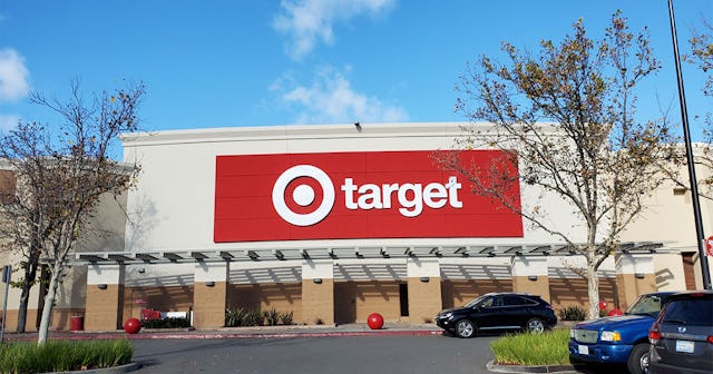A Target store featuring a prominent red billboard of their logo, with a parking lot in front.
