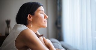 A woman with black hair sitting on a couch and thinking about the lessons she's learned from a lifet...