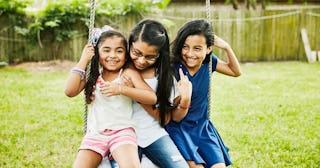 Three little girls who are sisters, two of them getting along with the one who is autistic