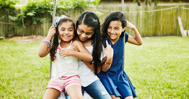 Three little girls who are sisters, two of them getting along with the one who is autistic