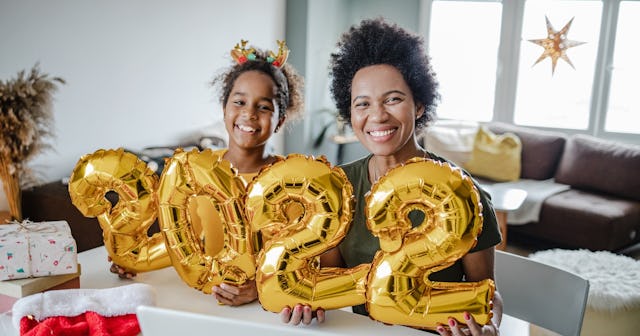 Woman and daughter posing with 2022 balloons — new year's colors