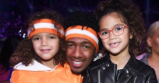 Nick Cannon with his two daughters smiling for a photograph 