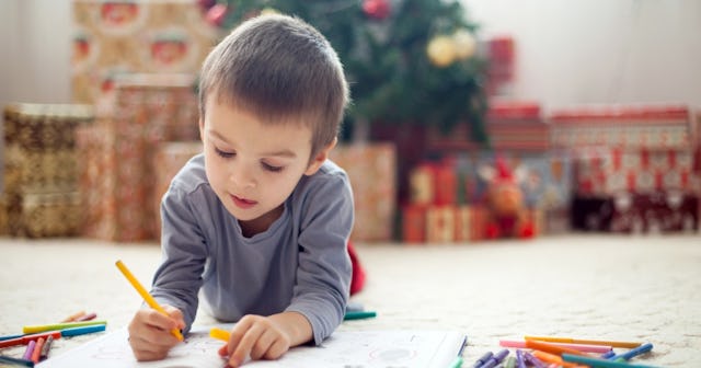 Child coloring in front of Christmas tree — Christmas tree coloring pages