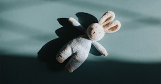 A stuffed bunny on a pastel green floor