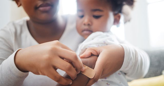 Mother applying a band-aid to her daughter's hand