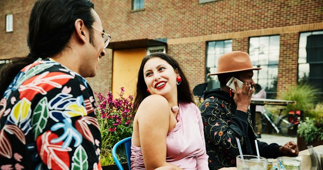 A man and a woman flirting while her partner is sitting next to her