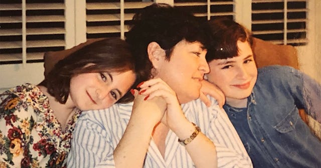 A woman in a white shirt with grey stripes, a girl in a floral top, and boy in a blue denim shirt le...