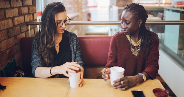 Two friends sitting in a cafe and drinking coffee