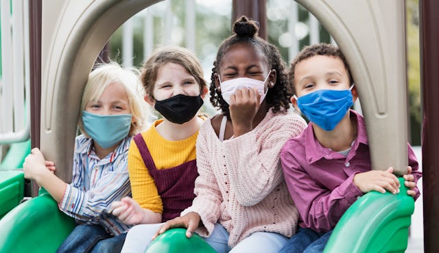 Four children on playground wearing masks to protect against Covid-19
