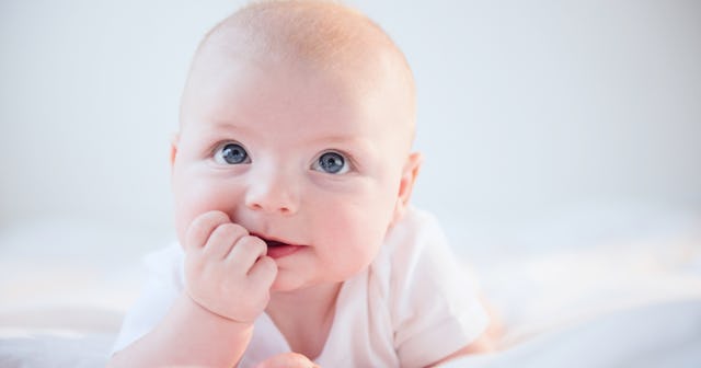 A cute, blue-eyed baby looks up.