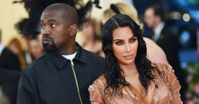 Former spouses Kim Kardashian in a Thierry Mugler dress and Kanye West in a black jacket posing toge...