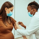 Woman getting vaccinated by a doctor at the hospital, since research showed no effect on fertility  