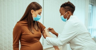 A pregnant woman getting vaccinated by a doctor at the hospital, since research showed no effect on ...