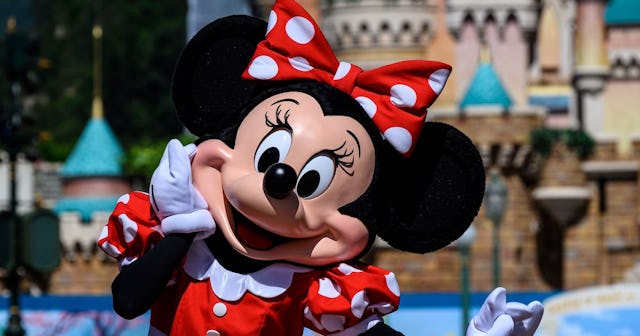 A person in a Minnie Mouse costume wearing a red dress in the Disneyland 
