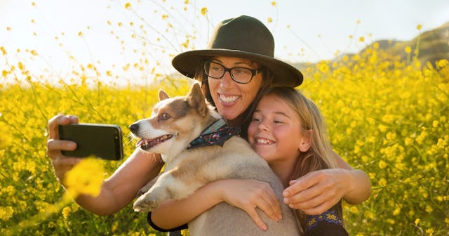 A mother and daughter take a spring selfie with their dog.