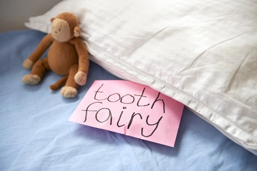 A child leaves their tooth under the pillow for the Tooth Fairy.