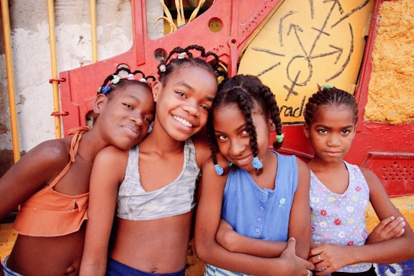 Girls pose in front of the Havana Club in Cuba
