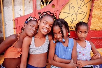 Girls pose in front of the Havana Club in Cuba