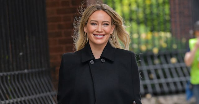 Hilary Duff in a black coat smiling to the camera and she wants to have more kids