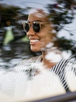 mom in sunglasses driving happy alone in car