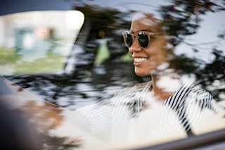 mom in sunglasses driving happy alone in car