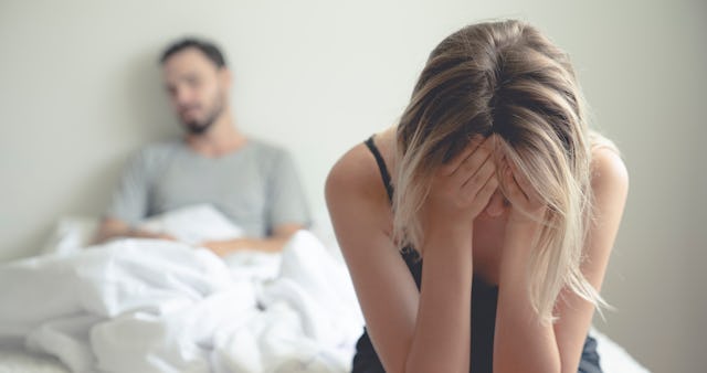 Unhappy married couple sitting together in bed