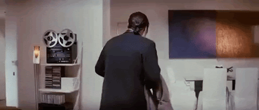 A GIF of John Travolta looking around a room