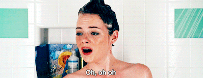 A GIF of Emma Stone in the shower singing