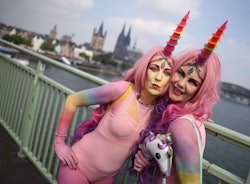 Two girls posing in pink unicorn Halloween costumes