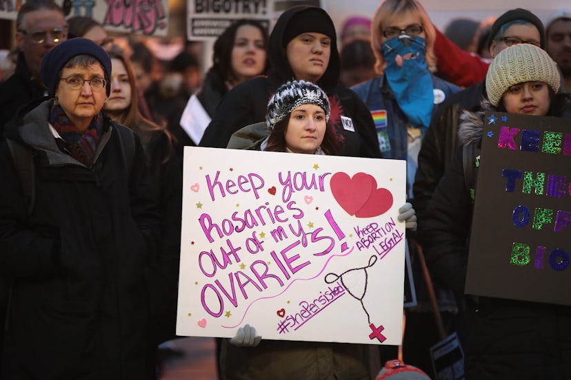 Women holding protest signs against closing the only abortion clinic in Missouri