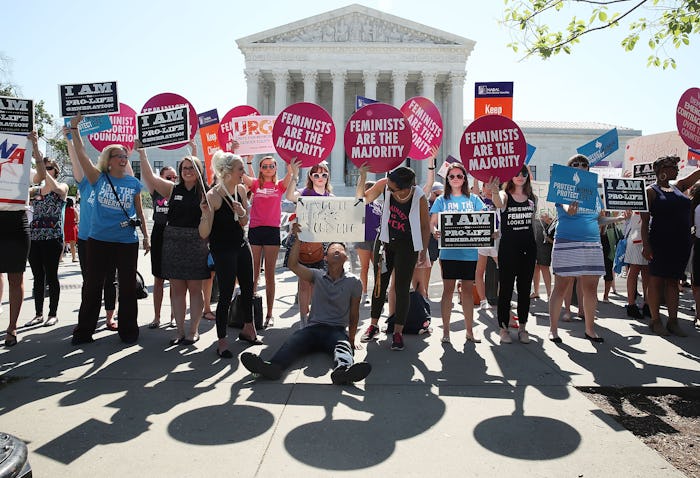 A group of demonstrators holding posters about the Crisis Pregnancy Centers in front of the SCOTUS