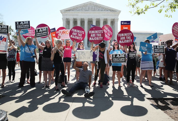 A group of demonstrators holding posters about the Crisis Pregnancy Centers in front of the SCOTUS