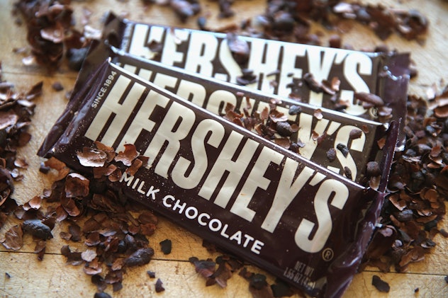 Three Hershey's chocolate bars laid on the table with chocolate sprinkled over them.