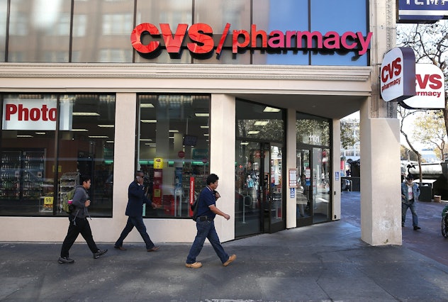 People walking in front of the CVS pharmacy.