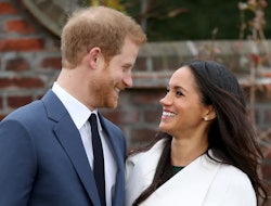 Meghan Markle and Prince Harry smiling at each other while hugging for a photo