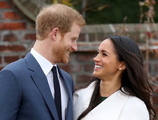 Meghan Markle and Prince Harry smiling while hugging for a photo