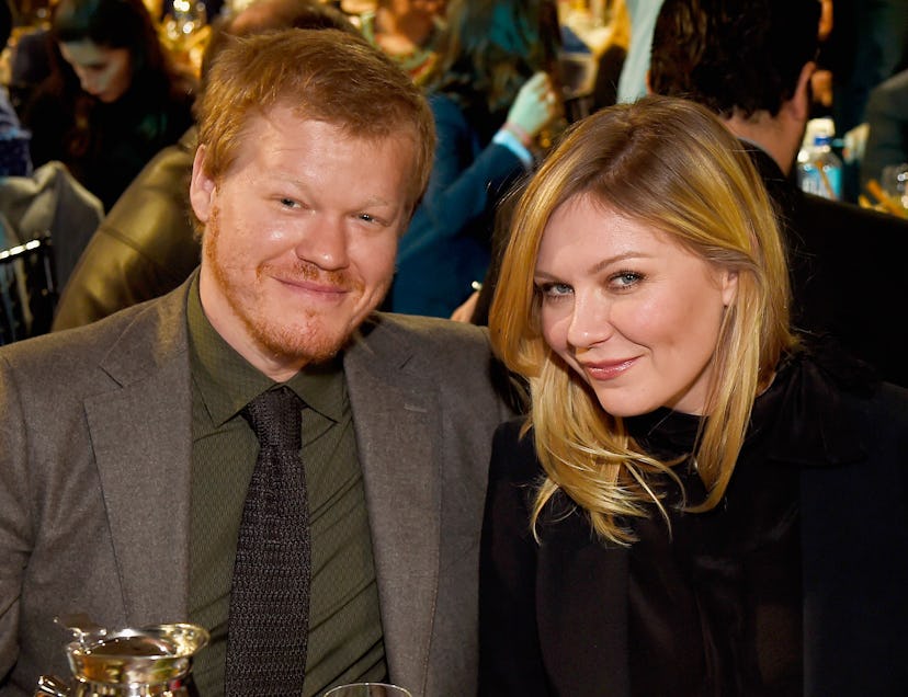 Kirsten Dunst and a man photographed sitting by the table at some event