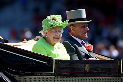 The Queen and Prince Philip riding in a ceremonial carriage.