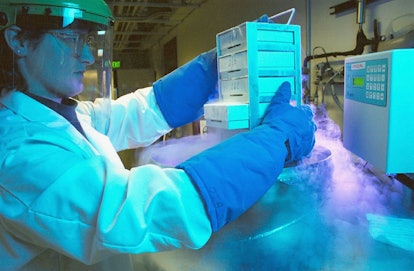 A scientist in protective gear handling equipment used to improve the ivf process