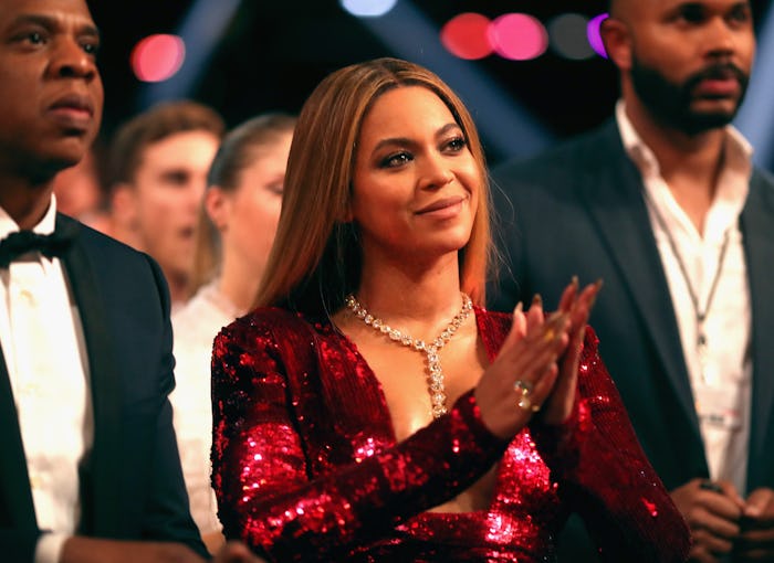 Beyoncé applauding in a red sequin dress