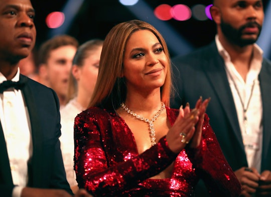 Beyoncé applauding in a red sequin dress